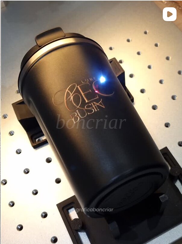 Copo térmico preto recebendo gravação a laser personalizada