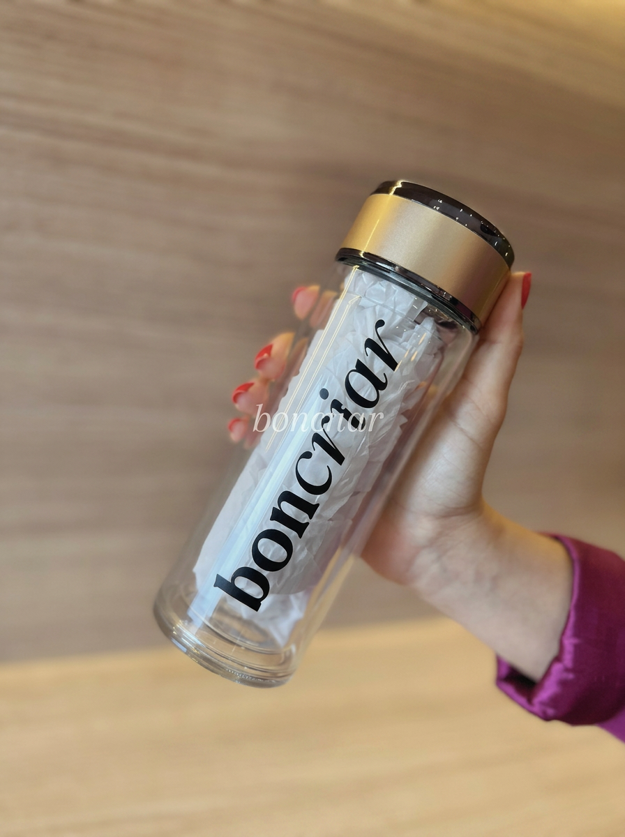 Garrafa infusora de vidro com tampa dourada e logo boncriar
